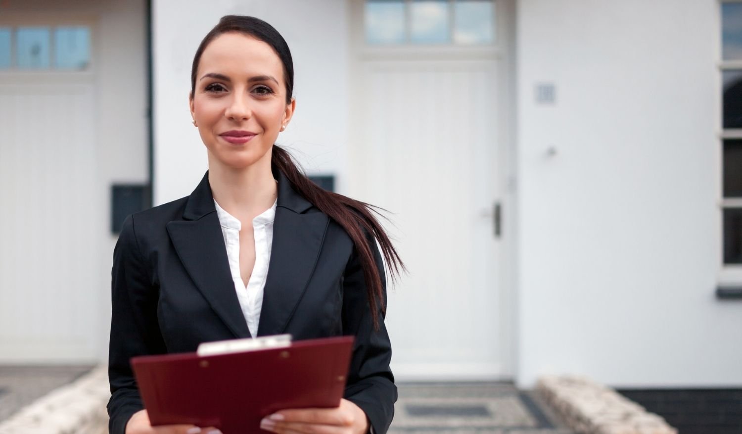 A realtor confidently awaiting open house attendees at her listing because she used the best real estate marketing tools available