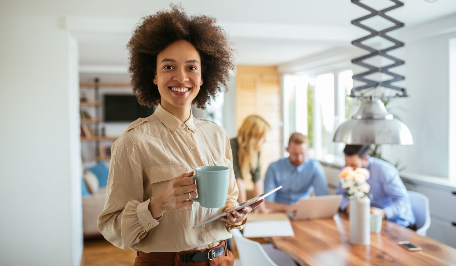 A realtor smiling while enjoying her coffee and dominating the real estate market