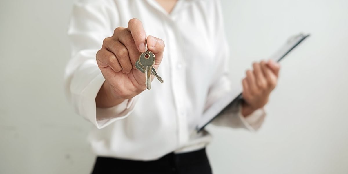 An agent handing a new home buyer the keys to their new home