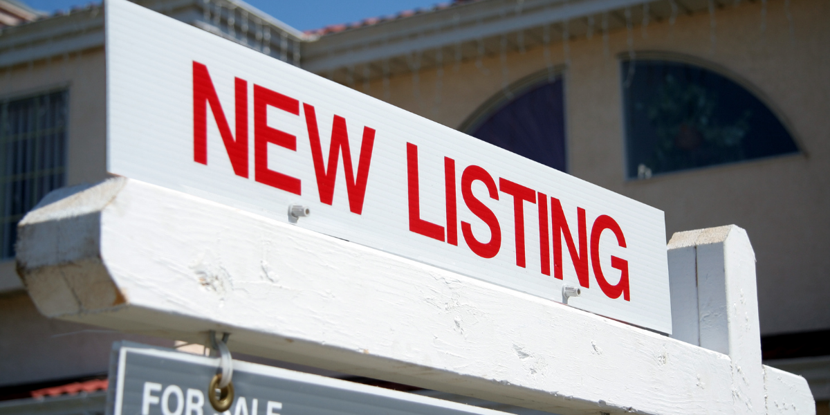 A new listing sign in front of a home for sale