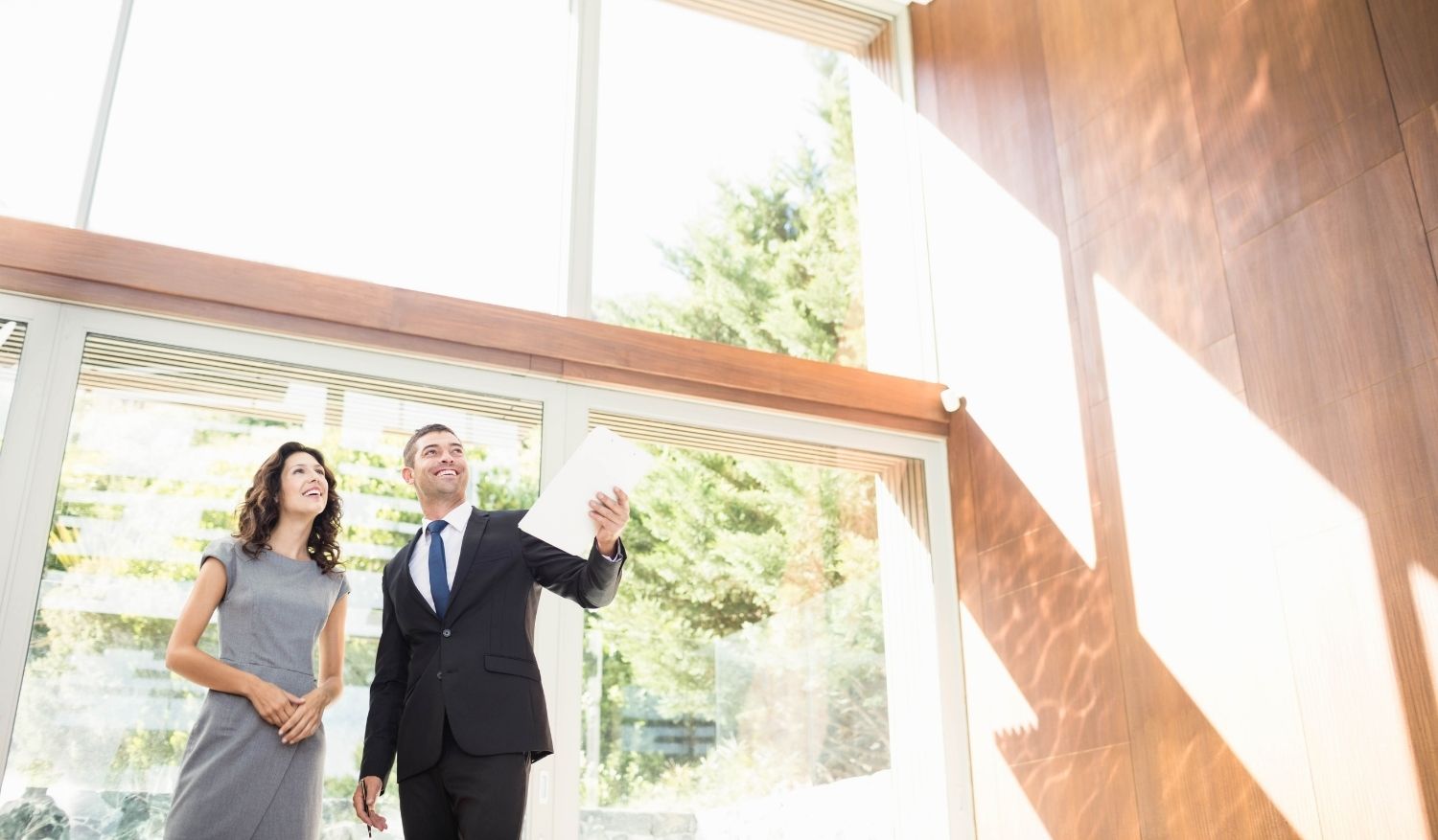 A male real estate agent showing a home to a female buyer who found him via his catchy real estate billboards