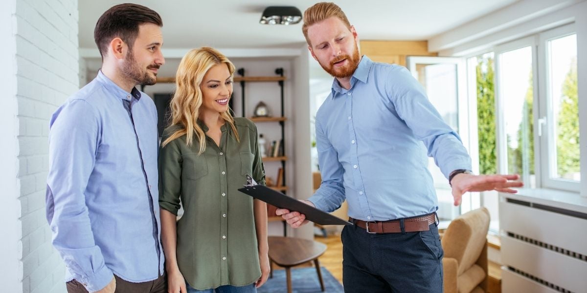 Real Estate Agent Showing Home To First Time Home Buyers