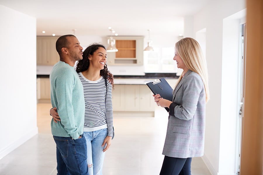 A real estate agent showing a home for sale to potential buyers