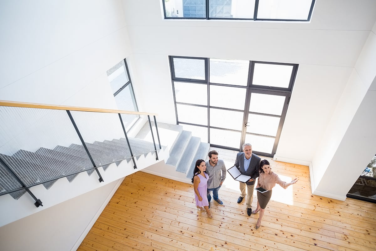 A real estate agent showing a house to happy local home buyers