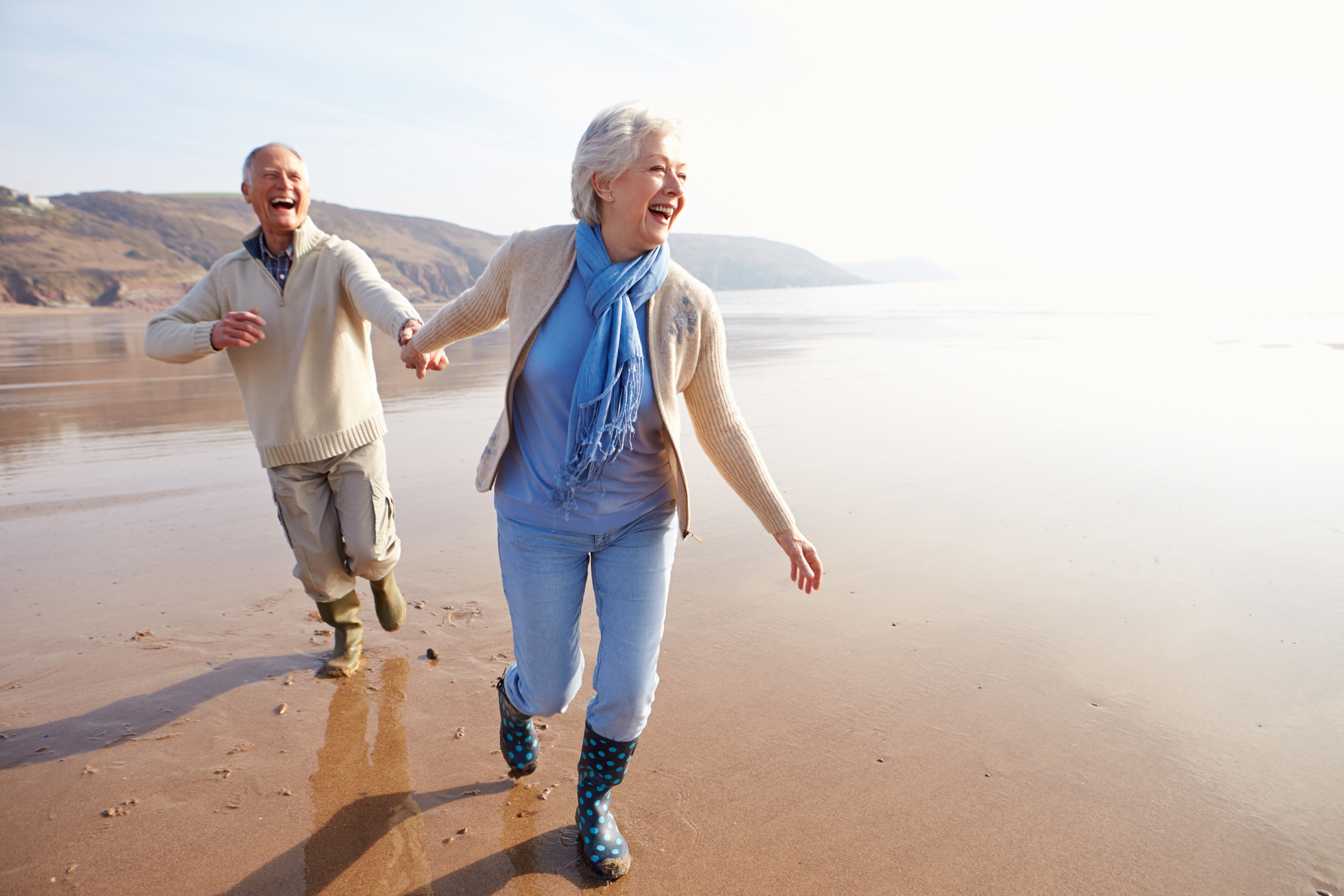 elderly couple enjoying the beach after moving to a new area