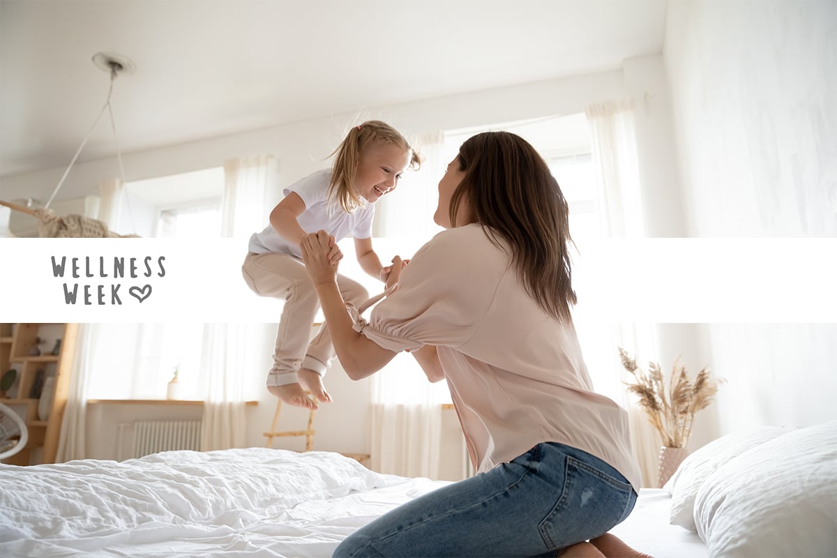 mother and daughter happy jumping on bed